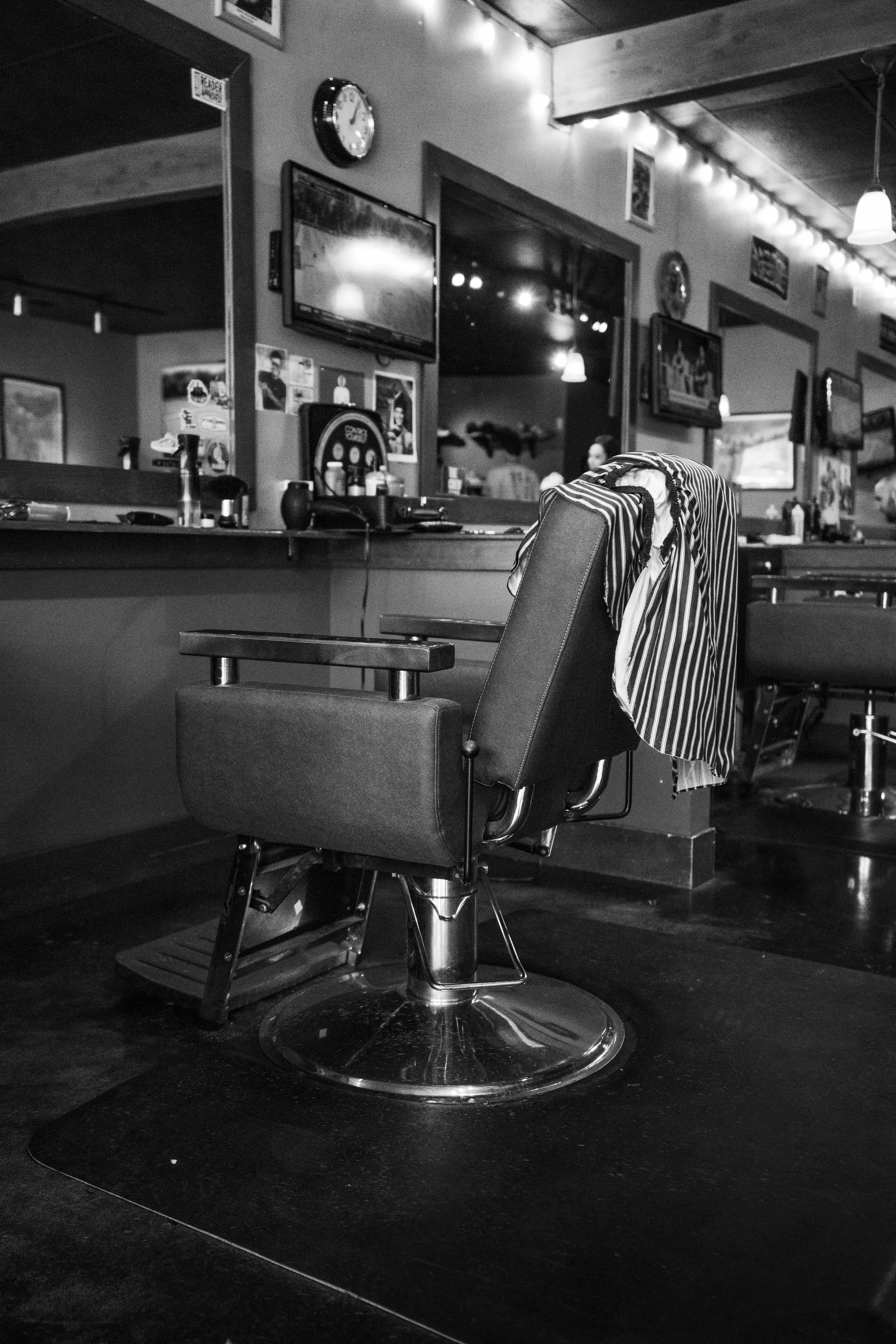Classic haircut chair with striped cape in traditional setting