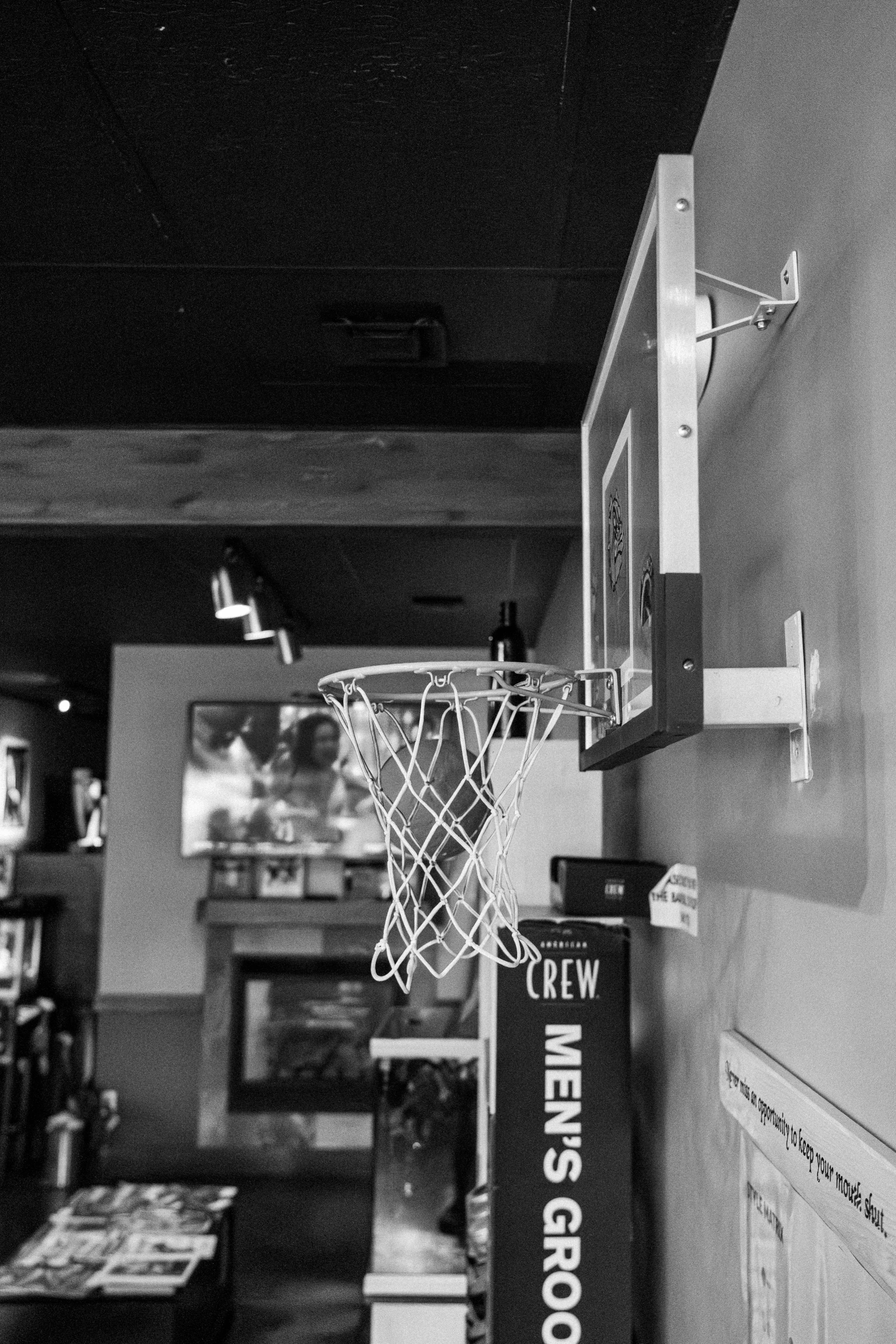 Basketball hoop mounted on wall with Men's Grooming Center signage