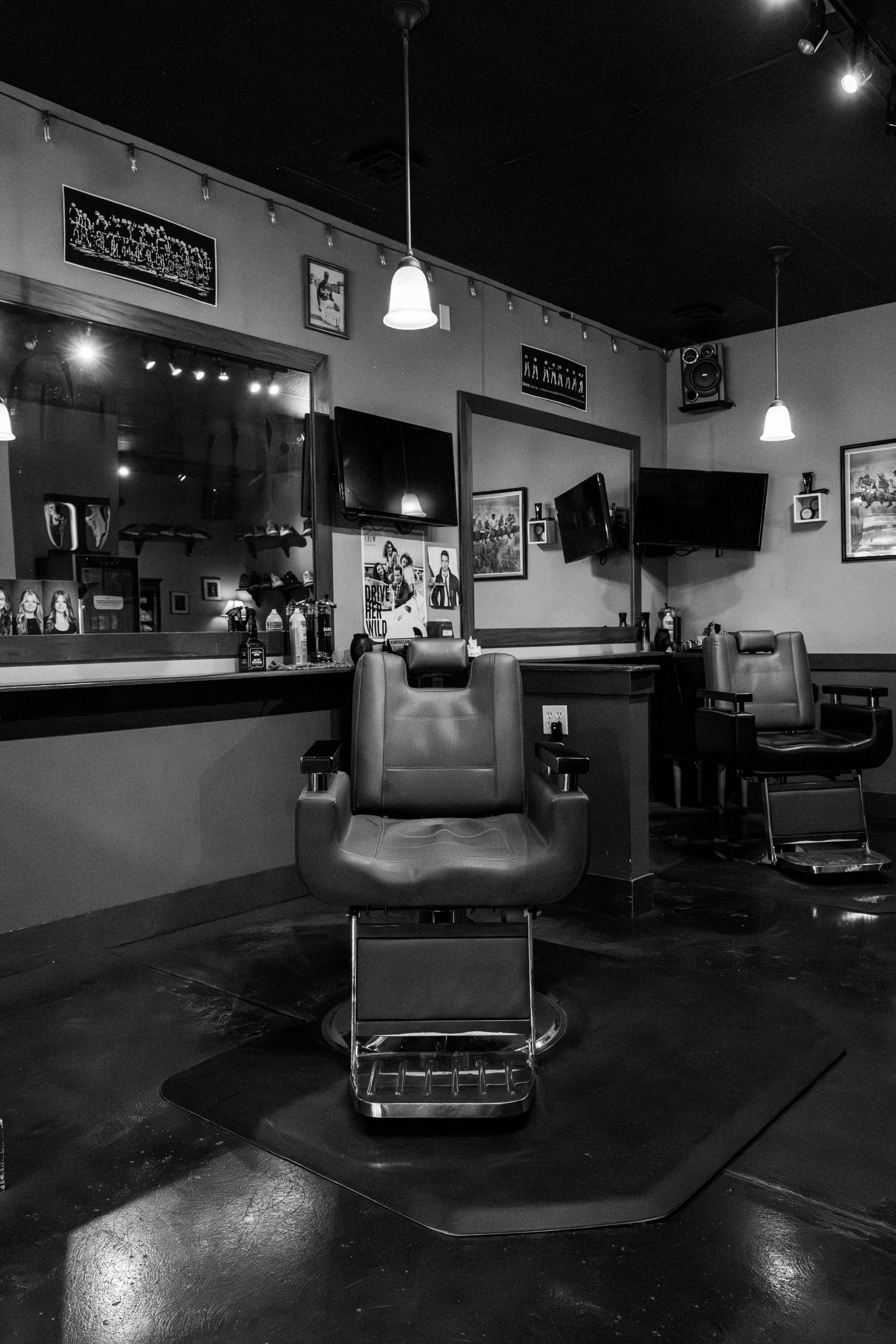 Black-and-white haircut interior with classic haircut chair, mirrors, and pendant lighting at Clean Cut CDA